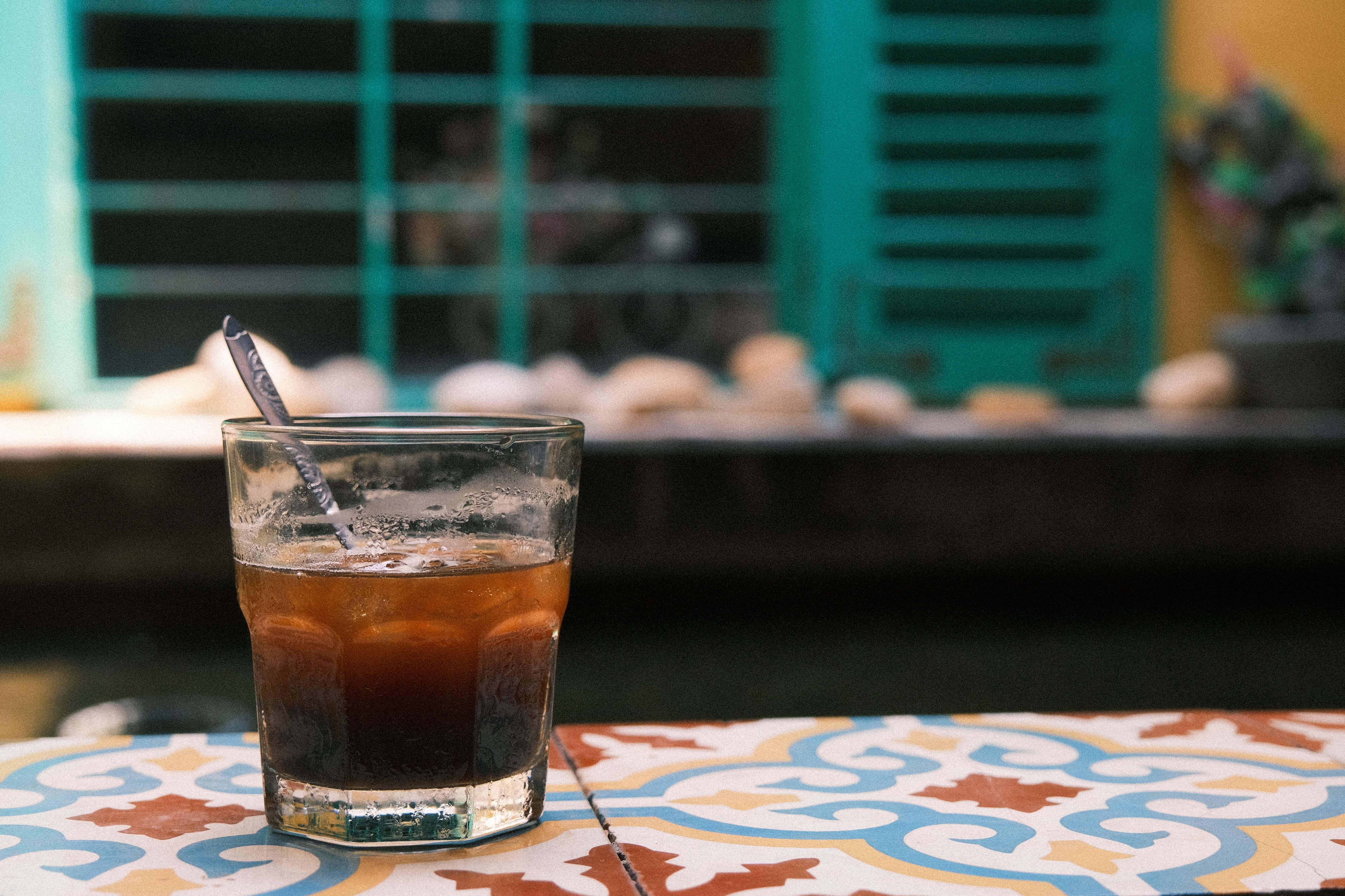 Iced Vietnamese coffee on a patterned cement-tile table