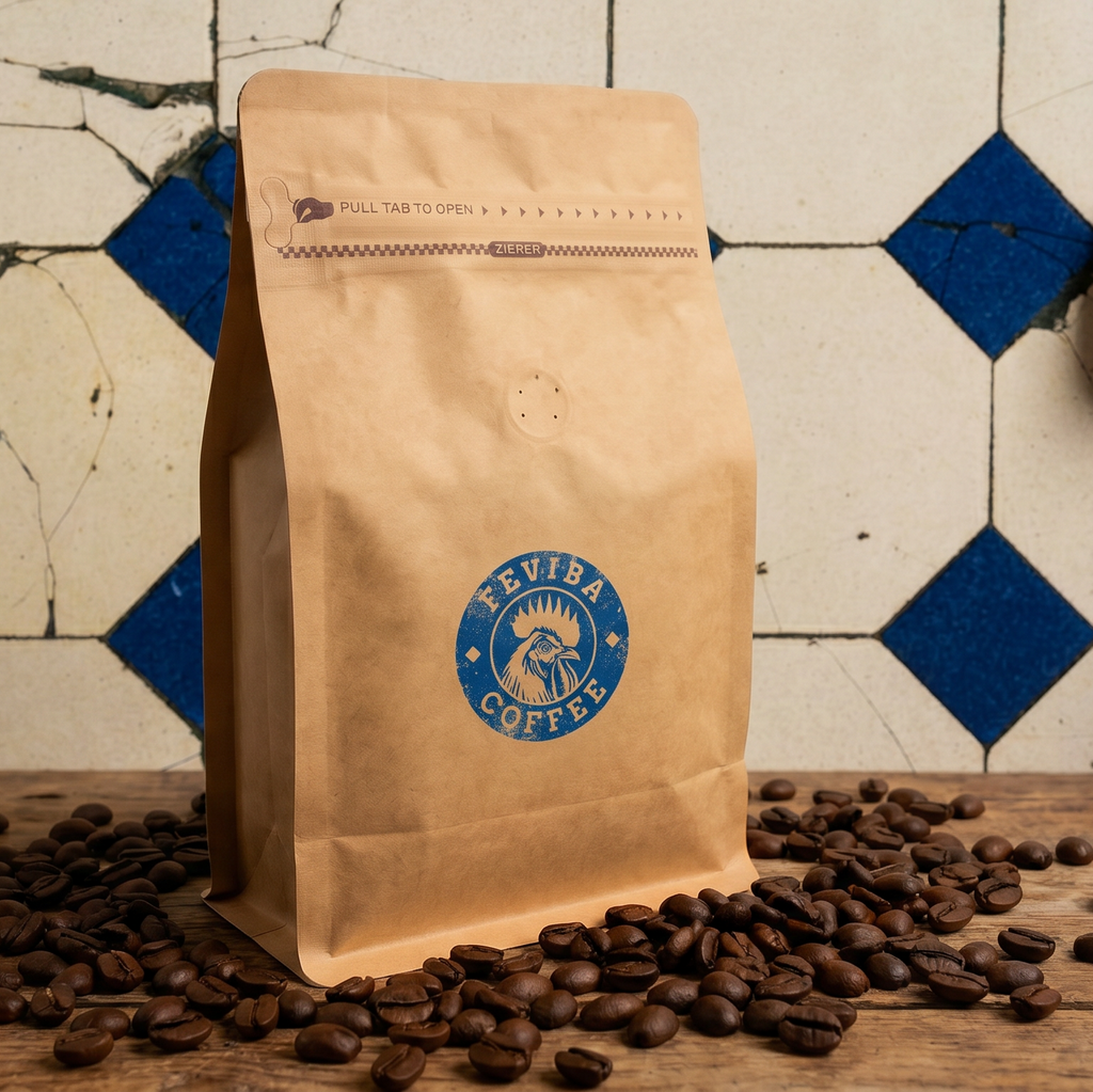 A kraft paper coffee bag with a blue circular 'FEVIBA COFFEE' logo stands on a wooden surface scattered with coffee beans, against a tiled wall with blue and white diamond patterns.
